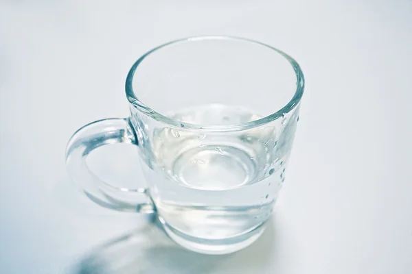Agua limpia en una taza de vidrio aislada — Foto de Stock