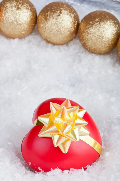 Christmas ball and heart in a gift — Stock Photo, Image