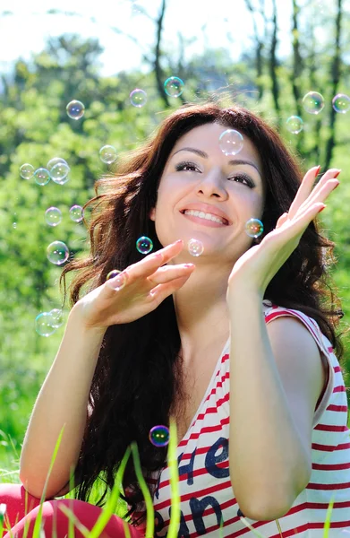 stock image Beautiful woman catches soap bubbles