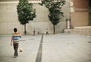 sokakta futbol oynayan çocuklar