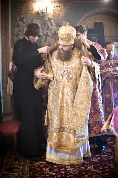 Två munkar hjälpa biskopen till mantel — Stockfoto