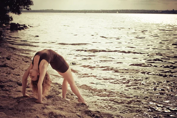 Donna sportiva che fa esercizio di stretching sulla banca — Foto Stock