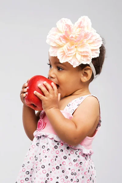 Милая маленькая девочка, кусающая яблоко — стоковое фото