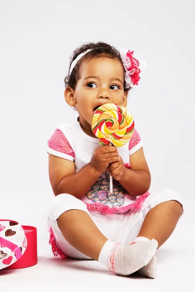 Прекрасна маленька дівчинка їсть великий льодяник — стокове фото