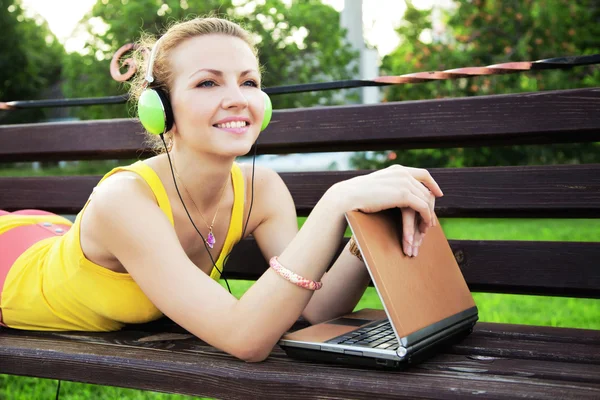 Mujer encantadora descansando en el parque con el ordenador portátil — Foto de Stock