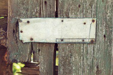 An old corroded banner on grungy wooden fence clipart