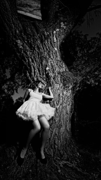 Beautiful girl leaned against a large tree