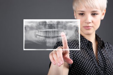 Young caucasian doctor and xray of teeth clipart