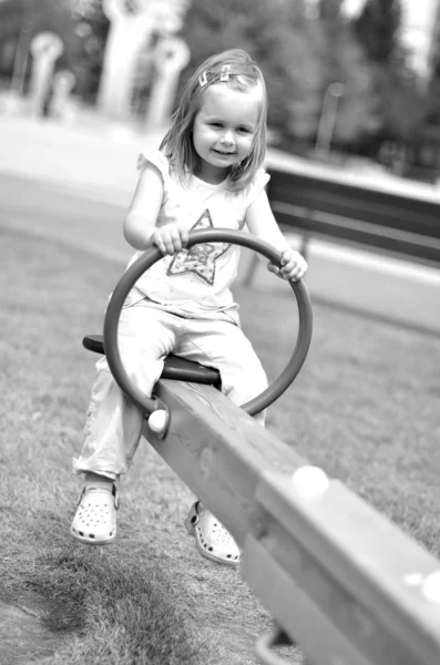 Ein kleines Mädchen spielt auf einem Spielplatz — Stockfoto