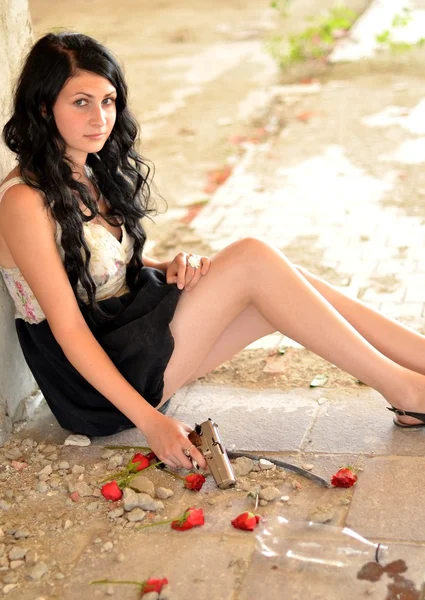 銃と花を持つ魅力的な若い女性 — ストック写真