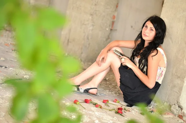 Atraktivní mladá žena s pistolí a květiny — Stock fotografie