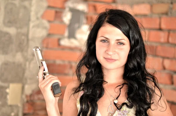 Aantrekkelijke jonge vrouw met een pistool — Stockfoto