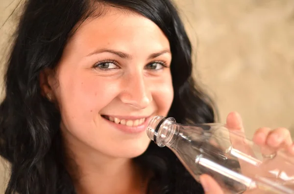 Mujer joven con una botella — Foto de Stock