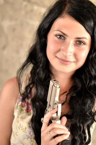 Attractive young woman with a gun — Stock Photo, Image