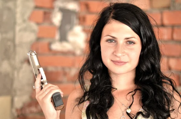 Attraktiv ung kvinna med en pistol — Stockfoto