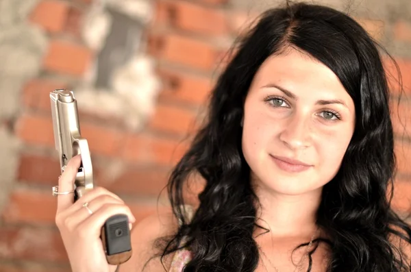 Vonzó fiatal nő egy pisztolyt — Stock Fotó