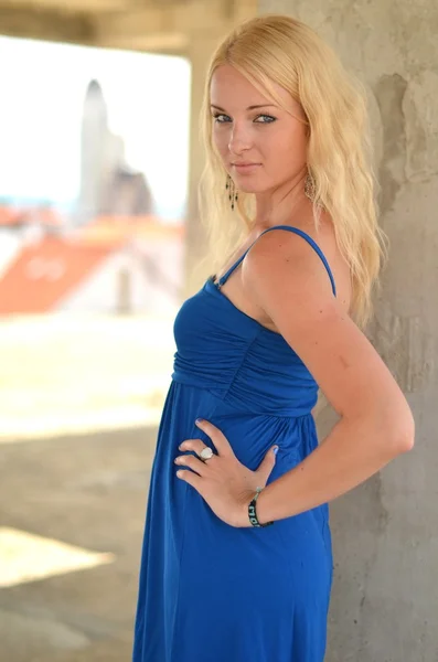 Молодая блондинка позирует в стильном синем платье — стоковое фото