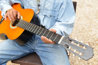 adam bir akustik gitar çalıyor