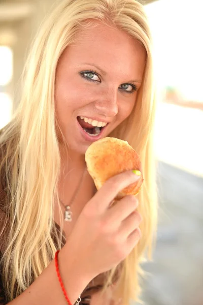 Porträt einer jungen Frau, die einen Donut isst — Stockfoto