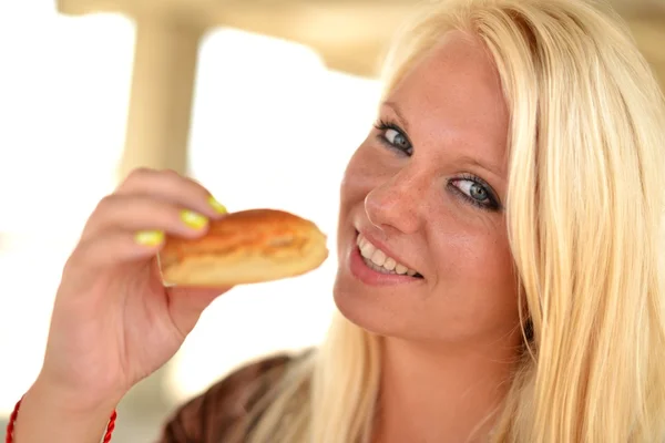 Retrato de uma jovem comendo um donut — Fotografia de Stock