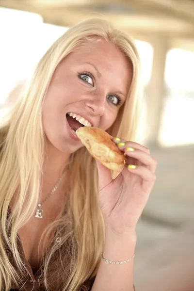 Portrét mladé ženy jíst koblihy — Stock fotografie