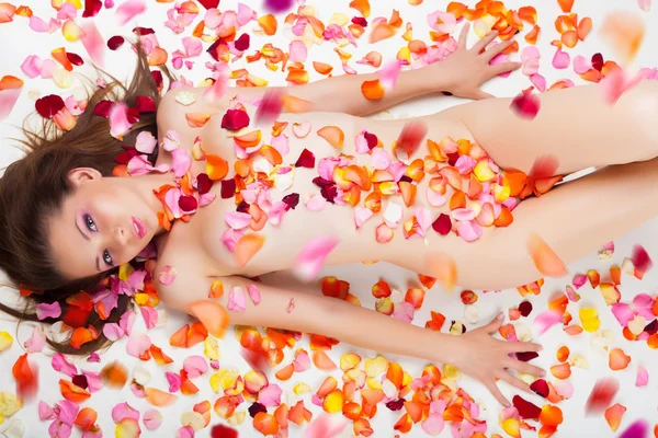 Mulher em pétalas de rosa — Fotografia de Stock