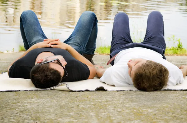 Två killar avkopplande utmed en flod — Stockfoto