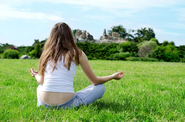 Woman meditates on green lawn — Stock Photo, Image