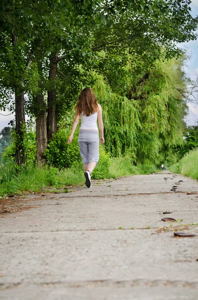 Jovem mulher correndo ao lado — Fotografia de Stock