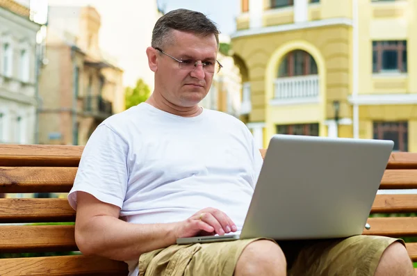 Man working on laptop in town