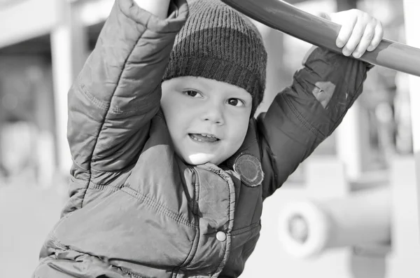 Kid in een jasje op een kinder speeltuin herfst — Stockfoto
