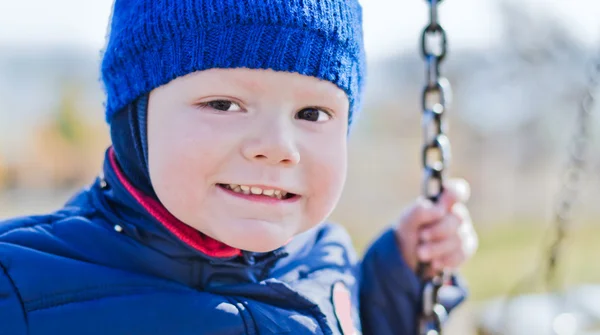 Iyi bir çocuk bir salıncak üzerinde gülümseyen — Stok fotoğraf