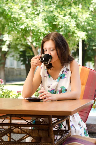 Kobieta pije kawę w kawiarni na świeżym powietrzu — Zdjęcie stockowe