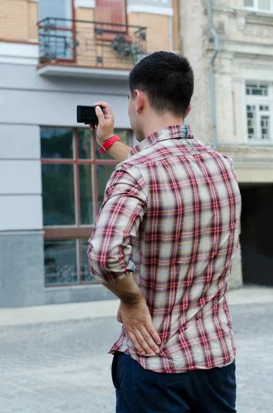 Молодой человек фотографирует здание — стоковое фото