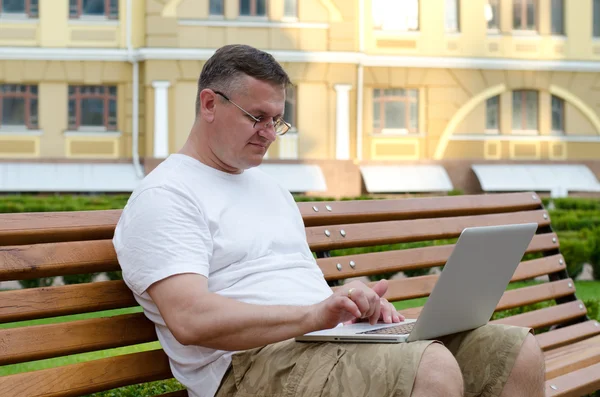 Man använder sin laptop i stan — Stockfoto