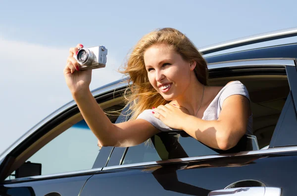 Tourist taking photographs from a car window — Stock Photo, Image