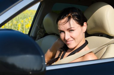 Smiling woman in a motor car clipart