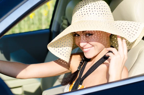 Woman driver in large sunhat — Stock Photo, Image