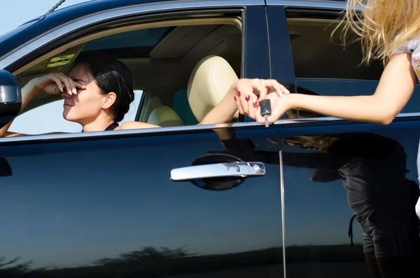 Moe vrouw stuurprogramma overhandigen van de autosleutels — Stockfoto