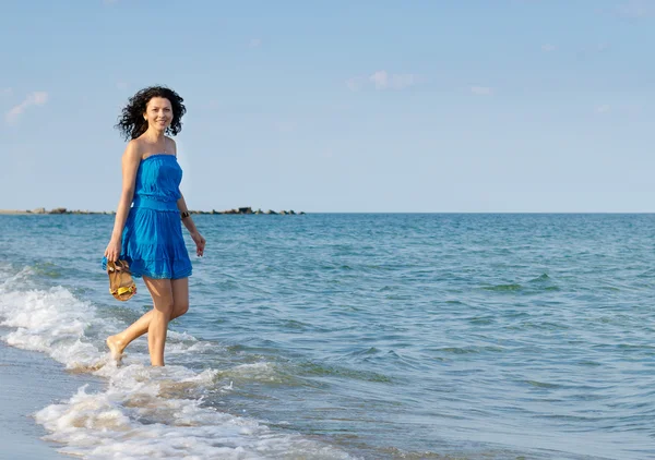 Счастливая женщина, брызгающая по волнам — стоковое фото