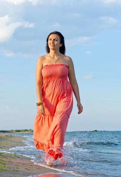 Женщина в длинном платье ходит по волнам — стоковое фото