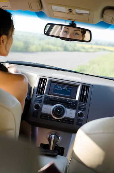 Mulher motorista olhando em seu espelho retrovisor — Fotografia de Stock