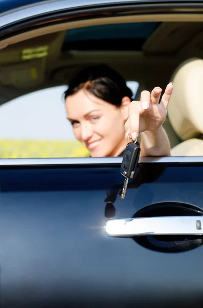 Woman handing a set of keys out of a car — Stock Photo, Image