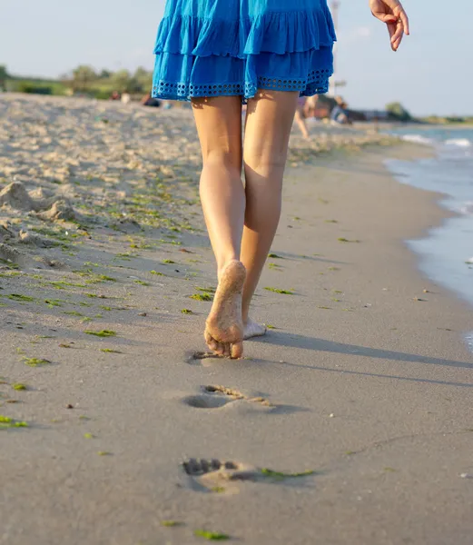 Босоногая женщина ходит по мокрому песку — стоковое фото