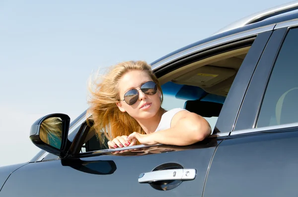 Mujer mirando hacia atrás desde la ventana del coche — Foto de Stock