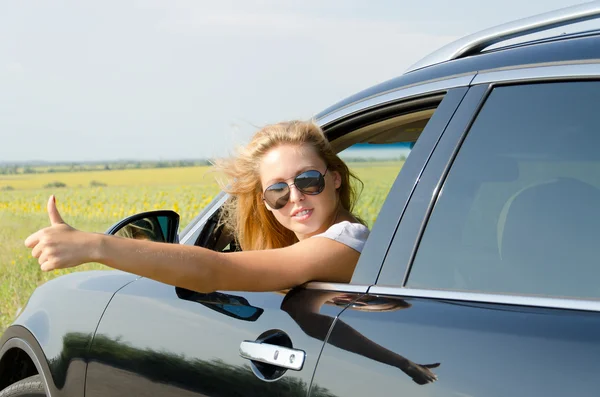 Mujer en coche dando un pulgar hacia arriba — Foto de Stock