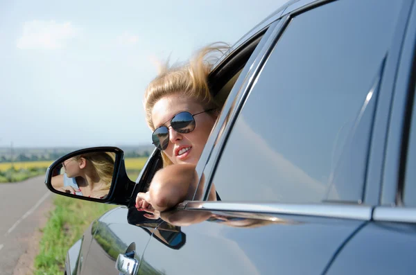 Žena při pohledu zpět z okna auta — Stock fotografie