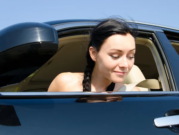 Woman looking out of her car at the ground — Stock Photo, Image