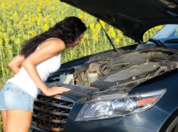 Женщина изучает двигатель автомобиля — стоковое фото