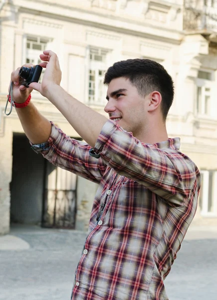 Smiling young man taking a photograph — Stock Photo, Image